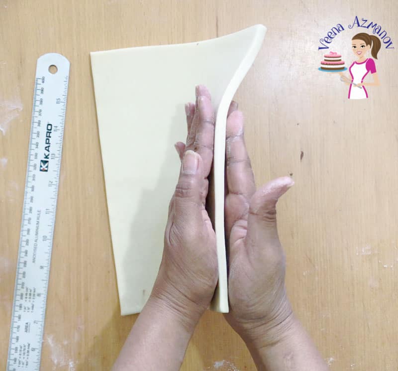 A person holding a sheet of puff pastry.