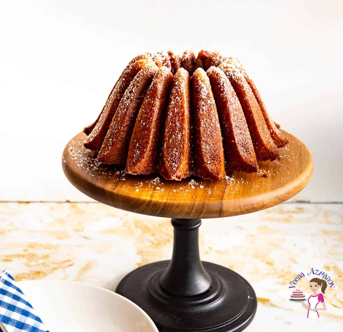 A strawberry bundt cake on a wooden cake stand