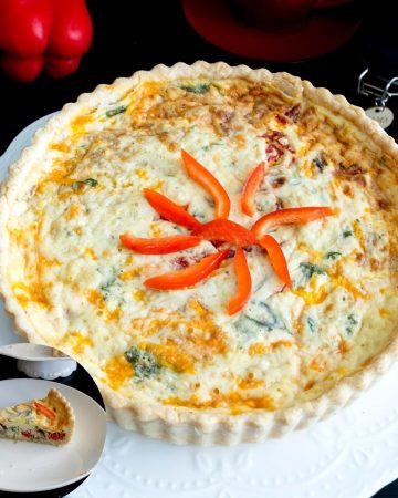 red peppers quiche on a cake stand.