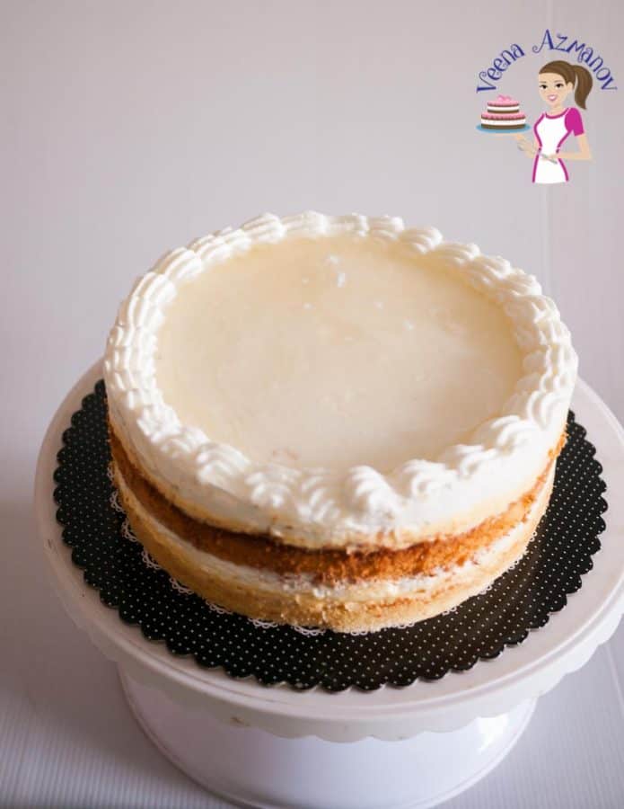 A mascarpone cream cake on a cake stand.