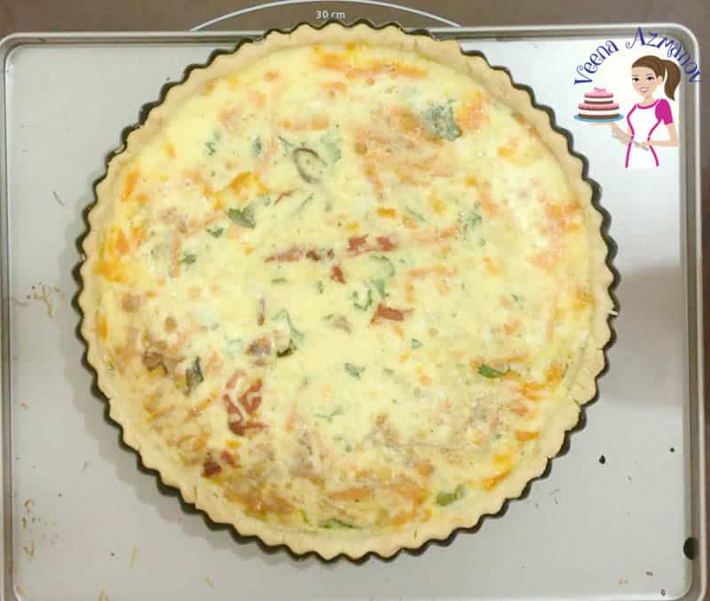A top view of a red peppers quiche in a tart pan.