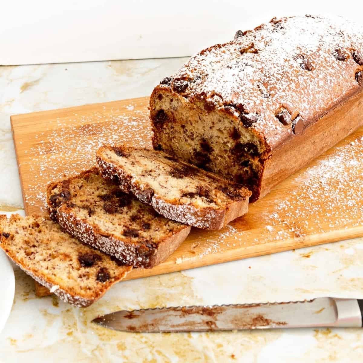 A wooden board with slices of banana cake.