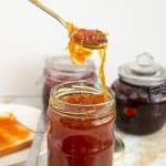 A spoon and jar with orange marmalade confiture d'orange.