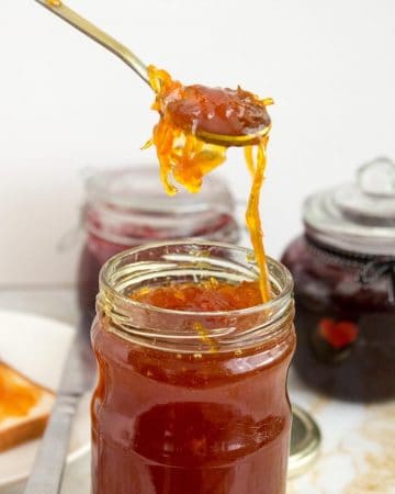 A spoon and jar with orange marmalade confiture d'orange.