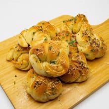 Garlic bread rolls on a wooden board.