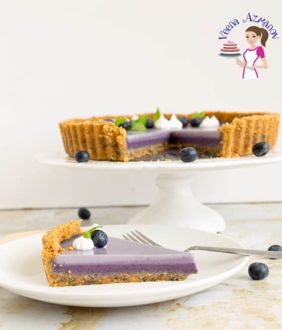 A slice of blueberry panna cotta tart on a plate.