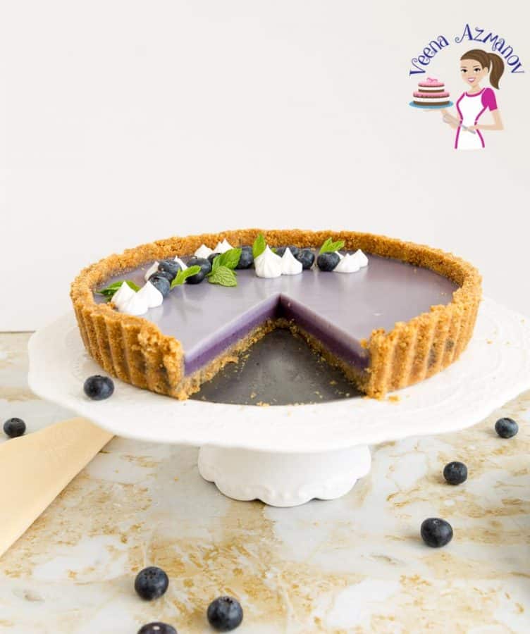 A blueberry panna cotta tart on a cake stand.