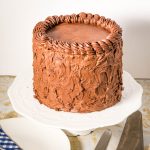 A frosted chocolate fudge cake on the table.