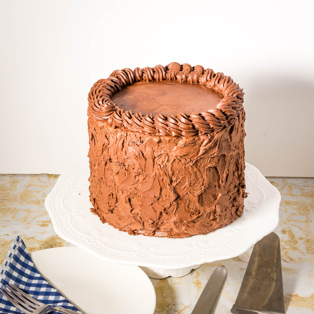 A frosted cake on the cake stand.