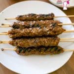 A stack of kebab skewers on a plate.
