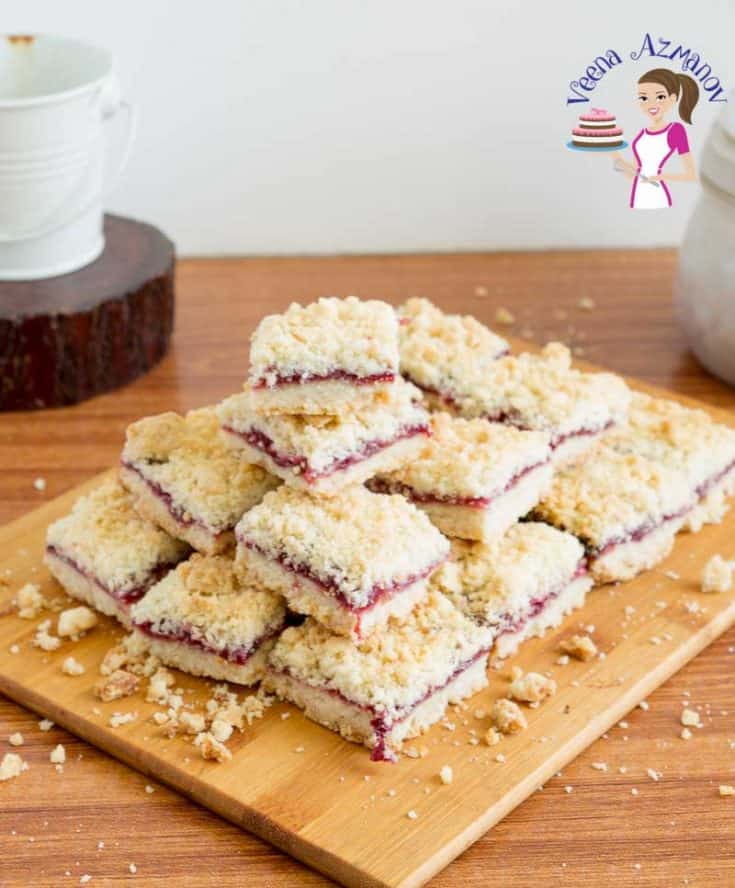 A stack of cherry crumble squares on a wooden board.