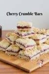 A stack of cherry crumble squares on a wooden board.
