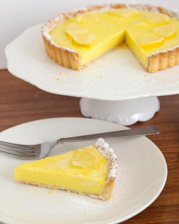 A slice on lemon tart on a plate