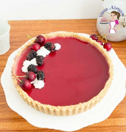 A blackberry Panna Cotta tart on a cake stand.