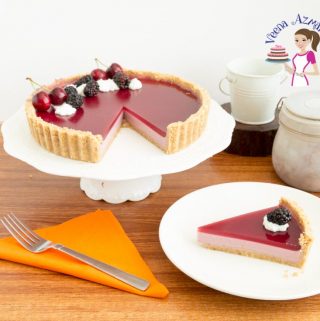 A blackberry Panna Cotta tart on a cake stand.