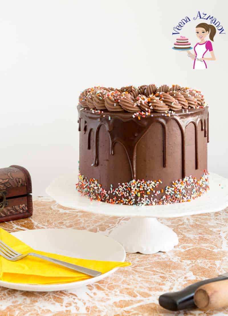 A chocolate birthday cake on a stand.