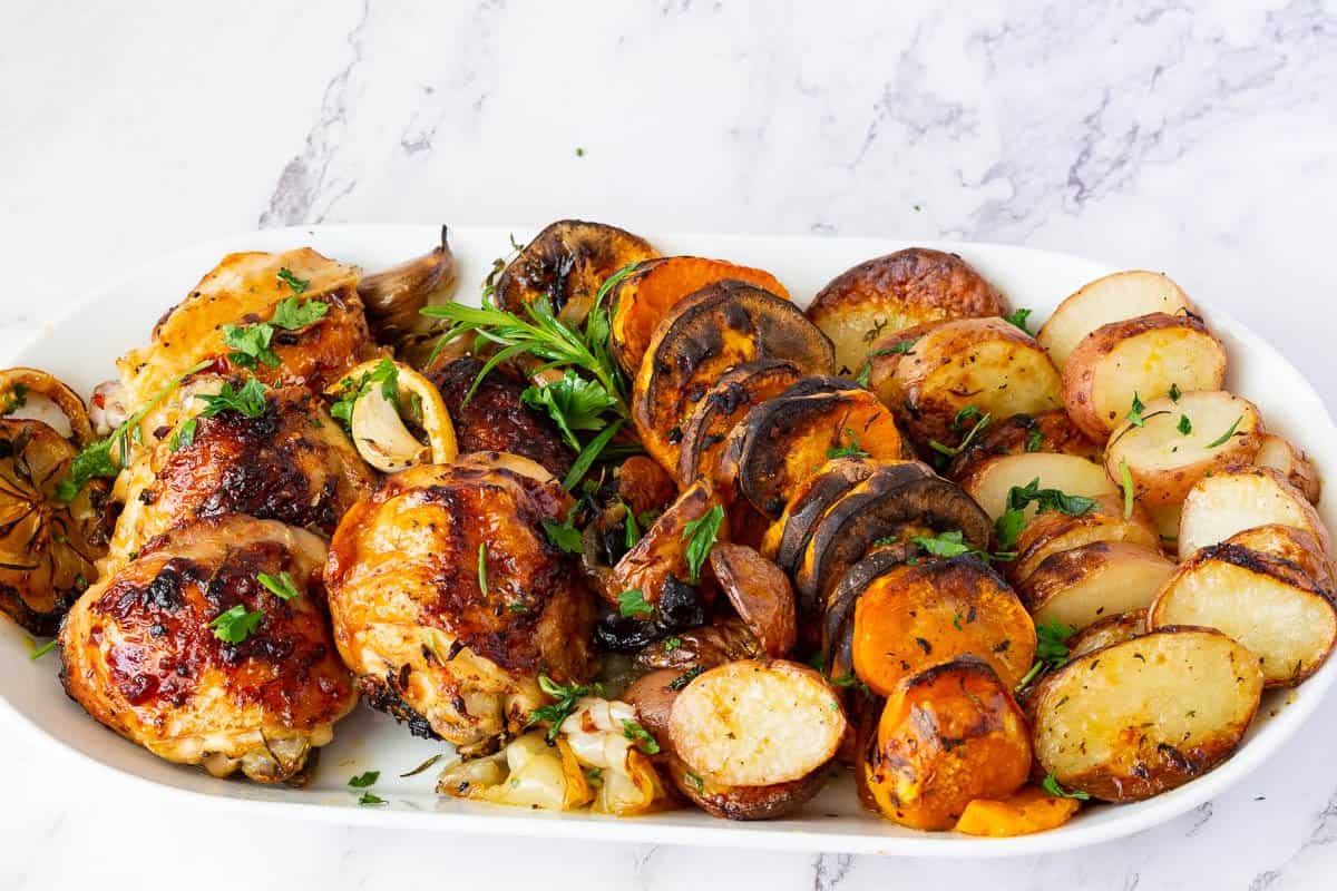 A platter with roast chicken in sheet pan.