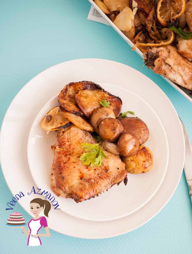 A plate of sheet pan chicken with mushrooms.
