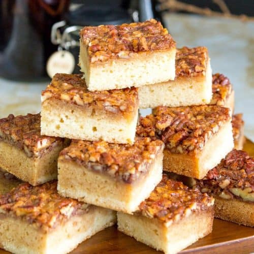 Stack of pecan blondies on a wooden board