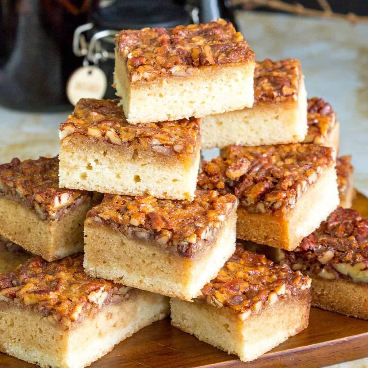 Blondies stacked on a wooden board.