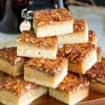Blondies stacked on a wooden board.