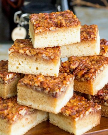 Blondies stacked on a wooden board.