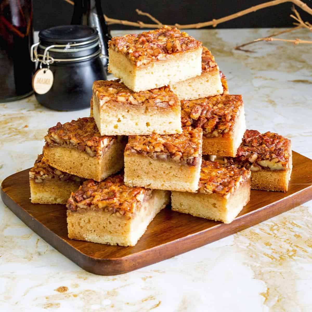 Blondies stacked on a wooden board.