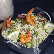 Shrimps over rice in a skillet.