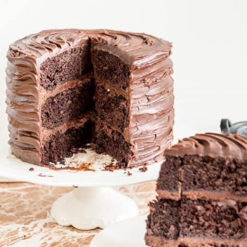 A sliced chocolate cake on a cake stand.