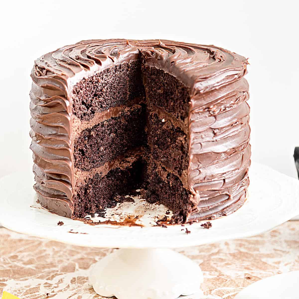 A sliced chocolate cake on the cake stand.