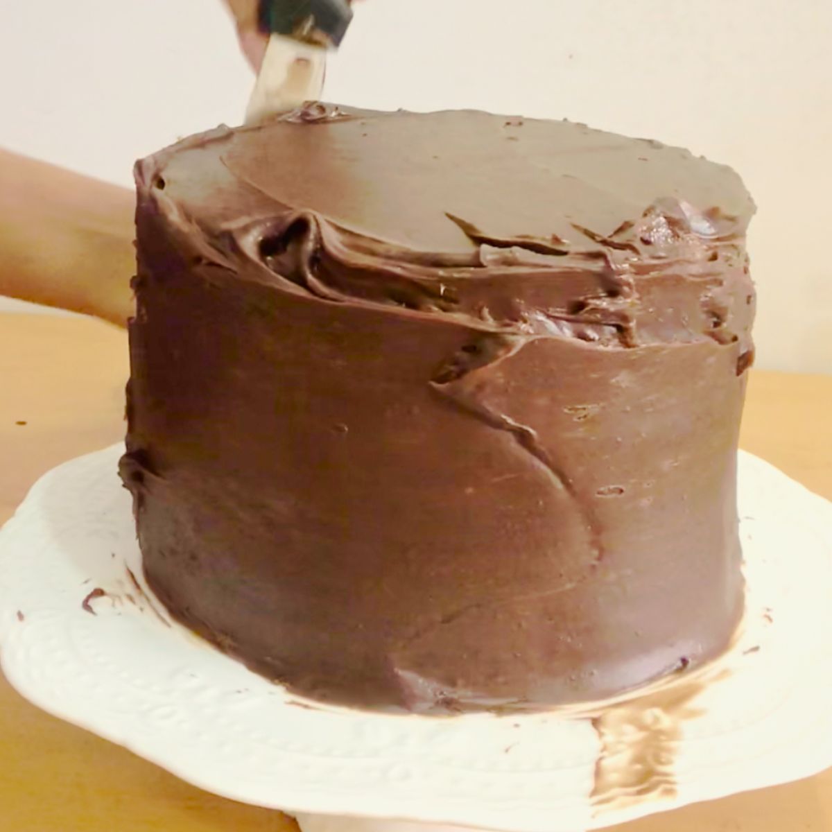 A chocolate cake frosted with ganache.