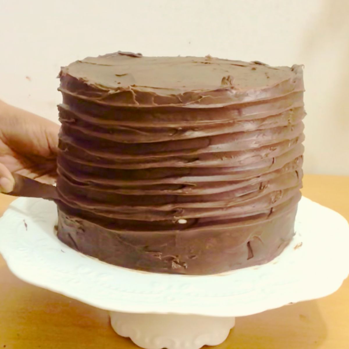 Frosting a death-by-chocolate cake with a spatula.
