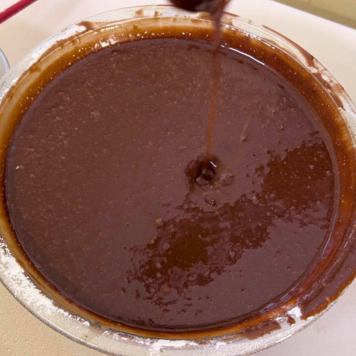 A glass bowl with chocolate cake batter.