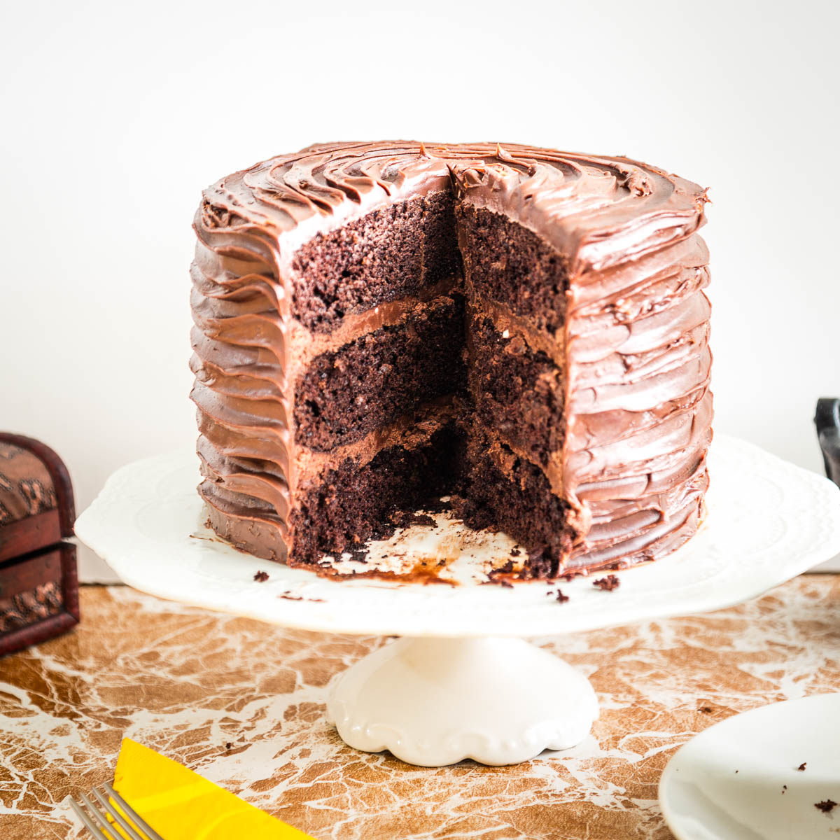 A sliced chocolate cake on the table.