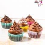 Chocolate cupcakes with Chocolate frosting on a table.