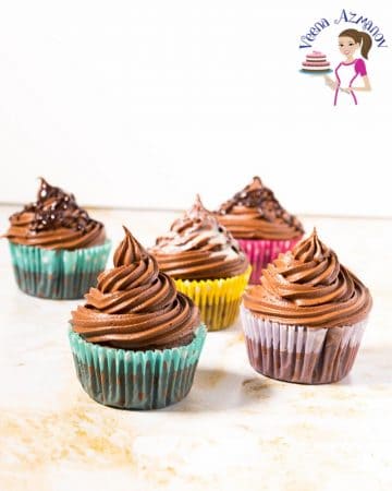 Chocolate cupcakes with Chocolate frosting on a table.
