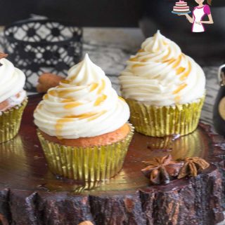Cupcakes with maple frosting on a wooden stand.