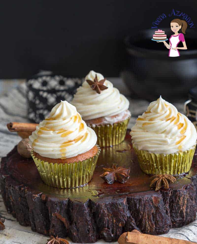 Cupcakes with maple buttercream frosting on a wooden stand.