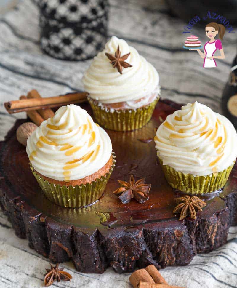Cupcakes with maple buttercream frosting on a wooden stand.