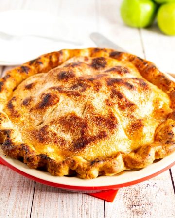 A pie in a pie pan with granny smith apples.
