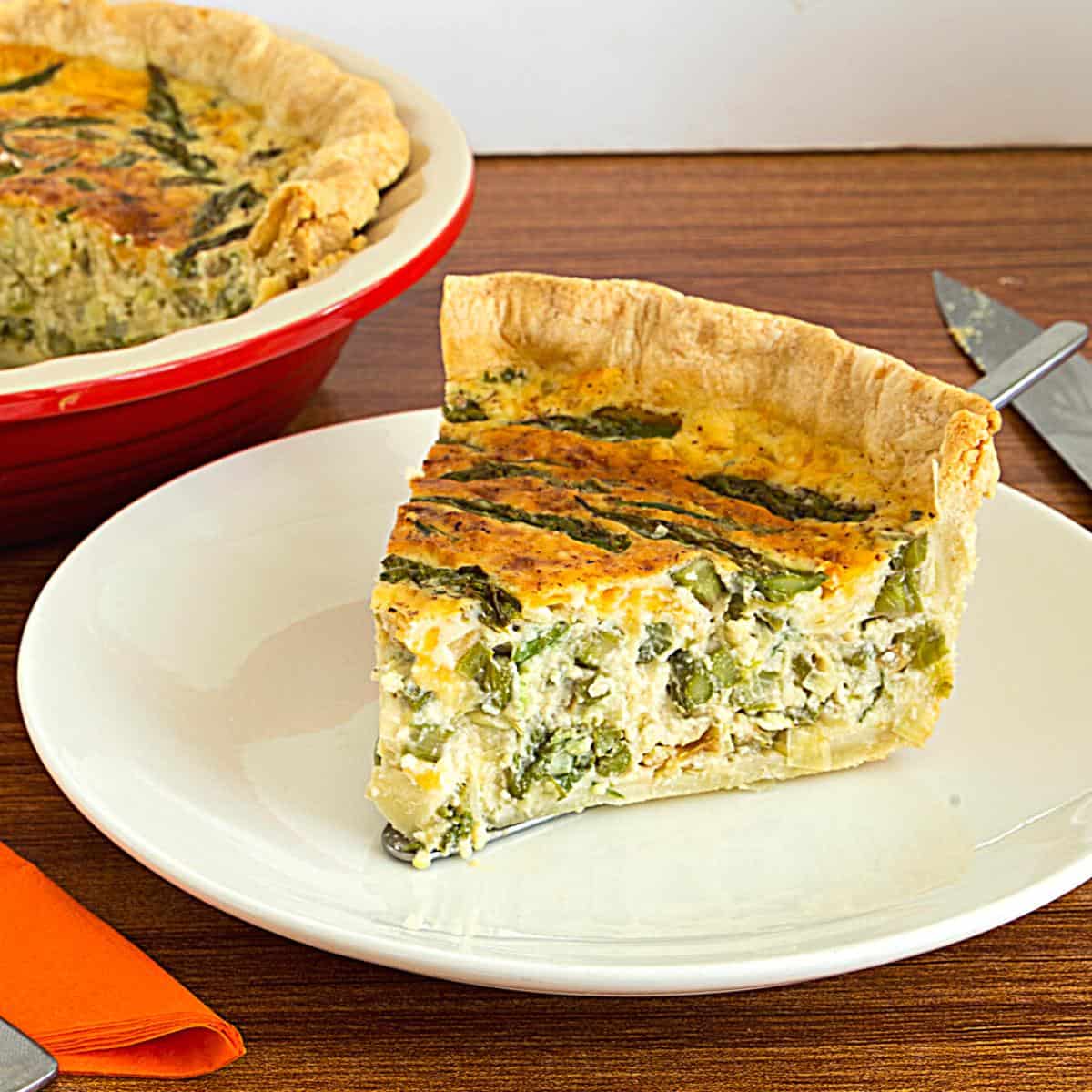 A slice of quiche with leeks and asparagus.