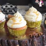Two cupcakes with maple buttercream frosting on a table.