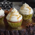 Cupcakes with maple buttercream frosting on a wooden stand.