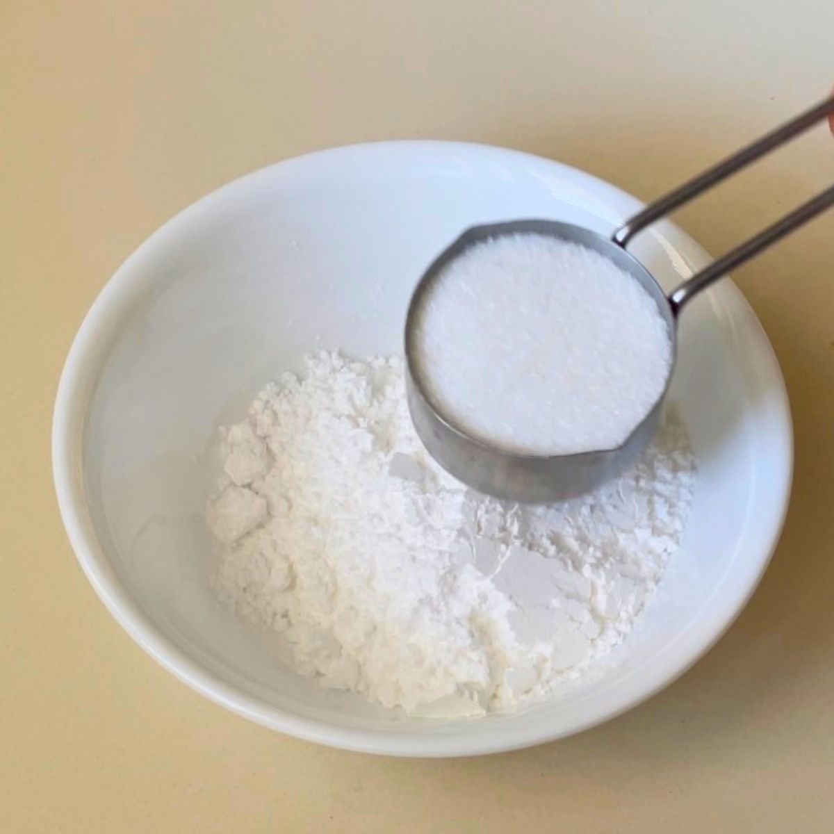 Combine the granulated sugar and powdered sugar in a white bowl.
