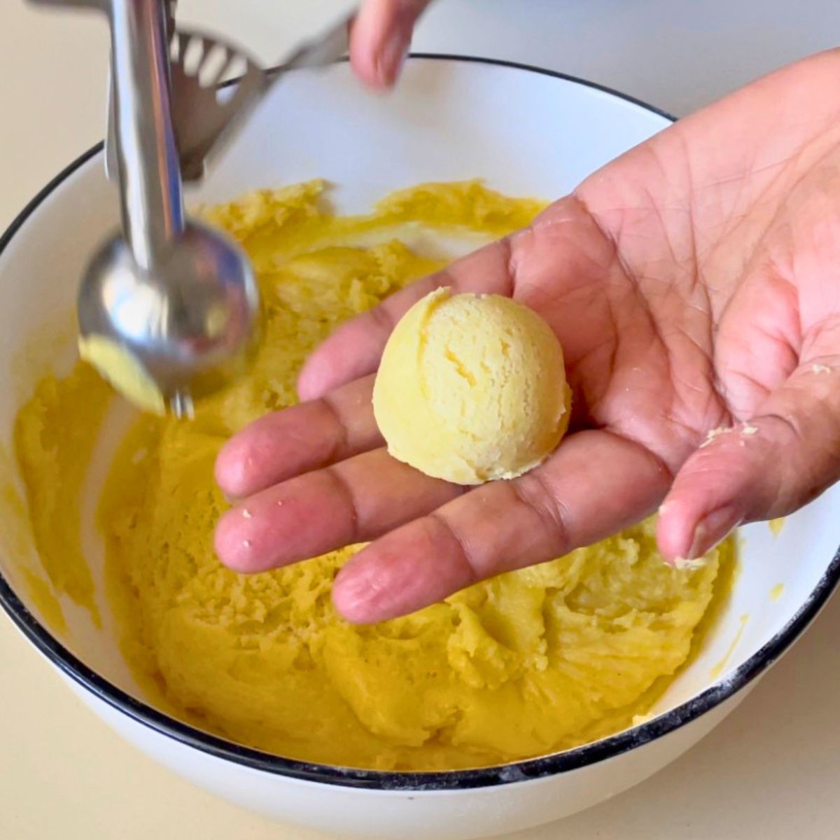 Shaping the lemon crinkle cookies into balls.