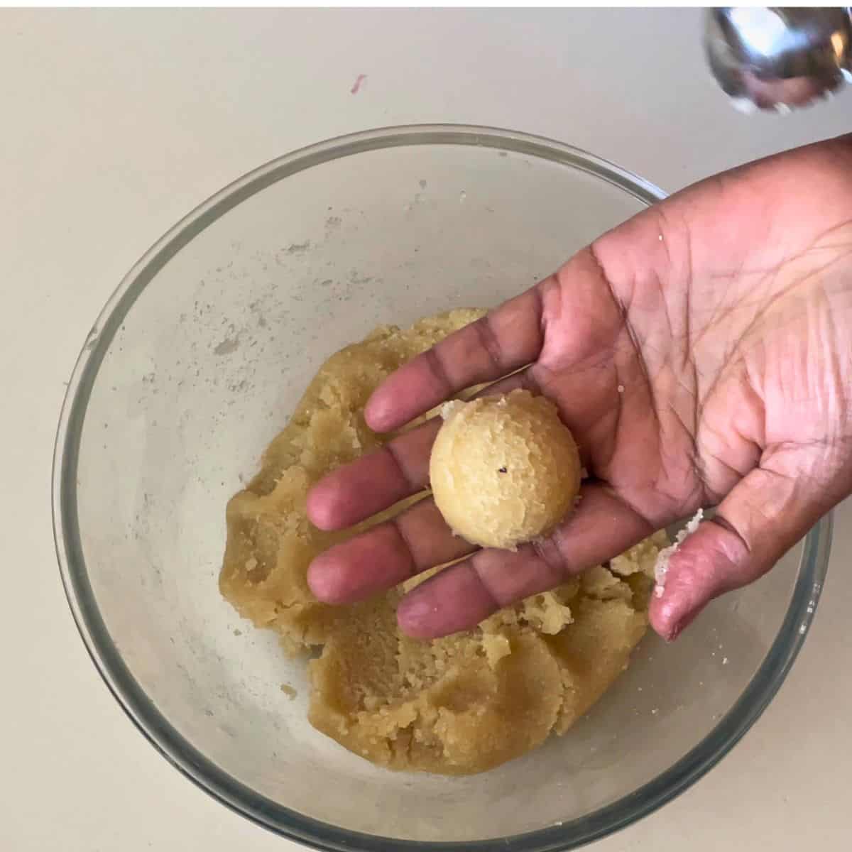 Shaping almond cookie dough into balls.