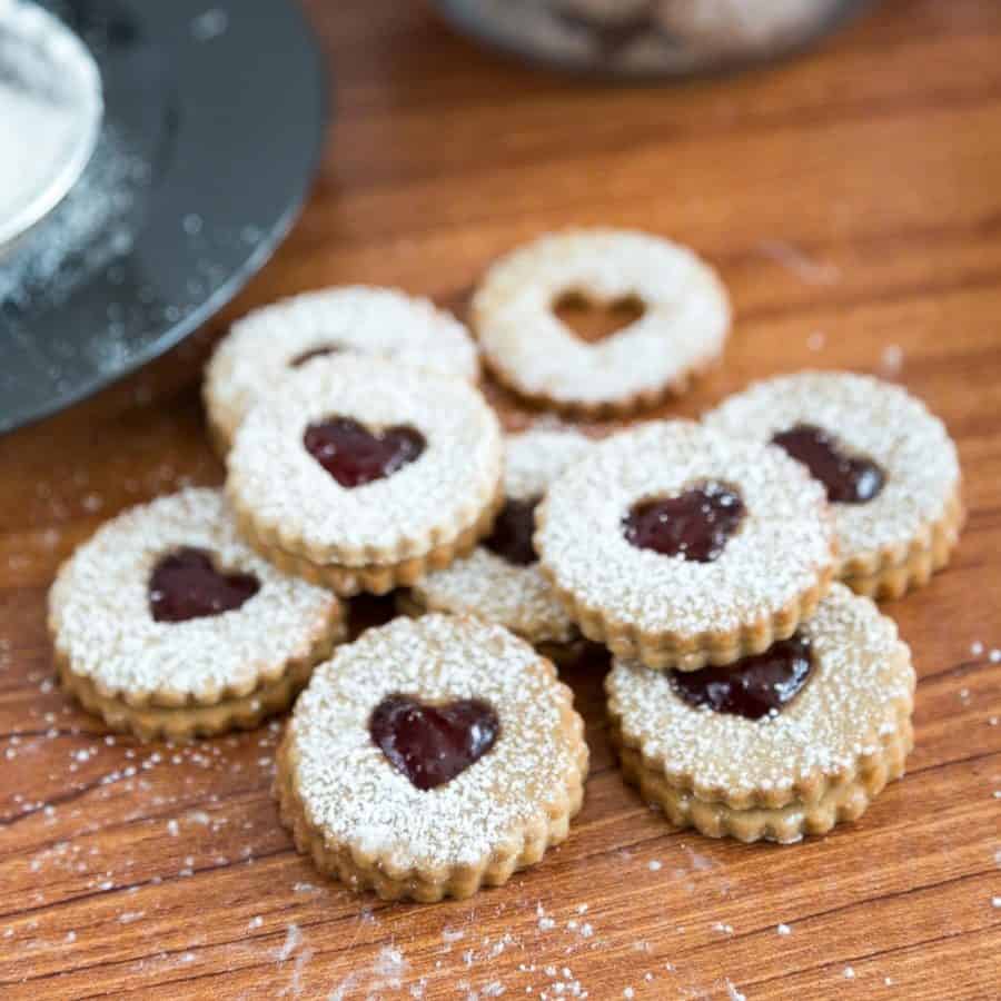 jam Linzer cookies on a wooden table