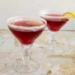 Two glasses of cranberry margarita on a table.