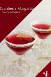 Two glasses of cranberry margarita on a table.