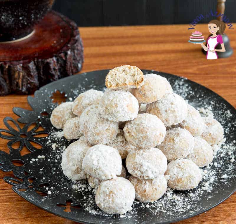 A stack of pecan and cranberries snowball cookies on a plate.